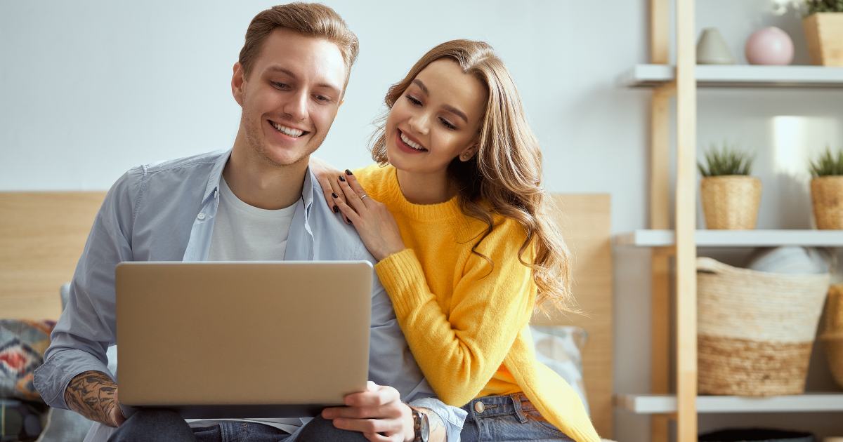 couple happy looking at laptop