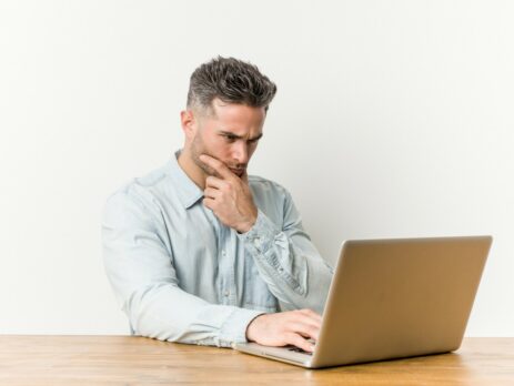 man thinking in front of laptop