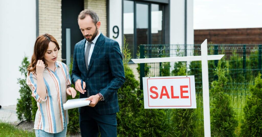 real estate broker talking to a woman with for sale sign